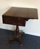 A rosewood two drawer tea poy on turned support an