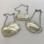 A group of three silver wine labels on suspension