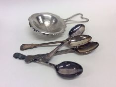 Four silver teaspoons together with a strainer. Ap