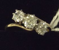 A large diamond three stone crossover ring in plat