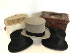 A boxed black top hat together with a grey top hat