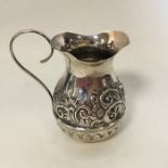 A small silver bachelor's cream jug embossed with
