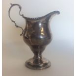 A Georgian style silver cream jug with gadroon rim