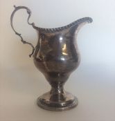 A Georgian style silver cream jug with gadroon rim