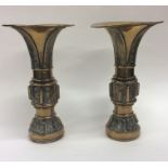 A pair of large brass spill vases with textured de