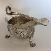 A Georgian chased silver sauce boat with card cut