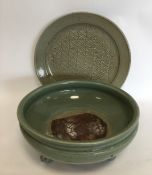 A massive celadon ground bowl on three tapering su