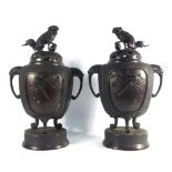 A pair of Japanese bronze patinated cast metal two handled covered koros of pumpkin shaped form,