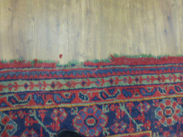 An early 20th century red ground rug with repeated motifs within red and blue bands, - Image 7 of 8