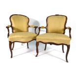 A near pair of 19th century French carved walnut and upholstered open armchairs on cabriole legs