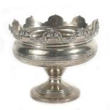 An Edwardian silver bon bon dish of circular form having a castellated foliate border raised on a