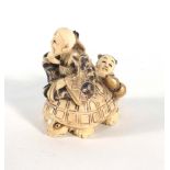 A carved netsuke modelled as two figures riding a turtle, signed, h. 6.