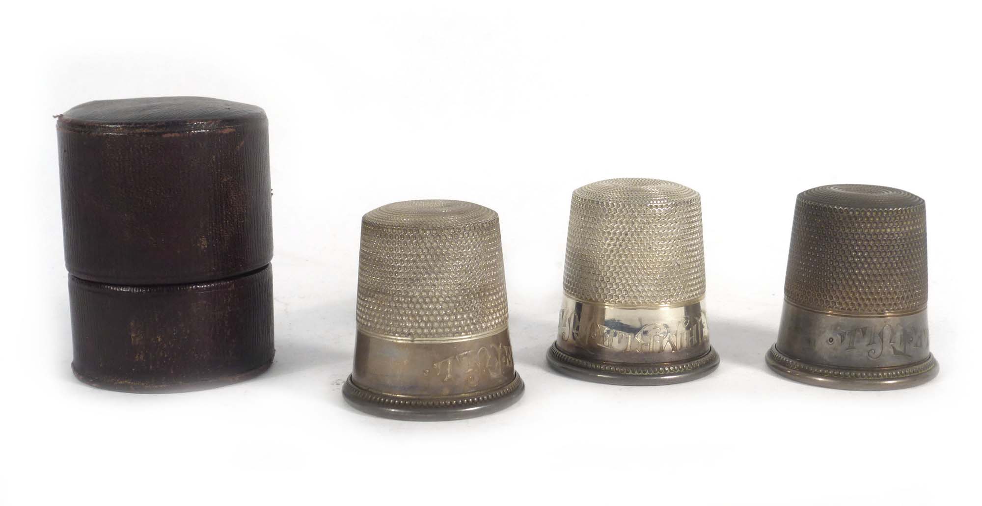 A set of three early 20th century novelty stacking metalware's and parcel gilt tot measures,