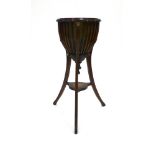 A late 19th/early 20th century mahogany jardiniere with a brass liner,