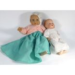 A toy crib containing an Armand Marseille 'Dream Baby' doll and a larger soft plastic doll (3)