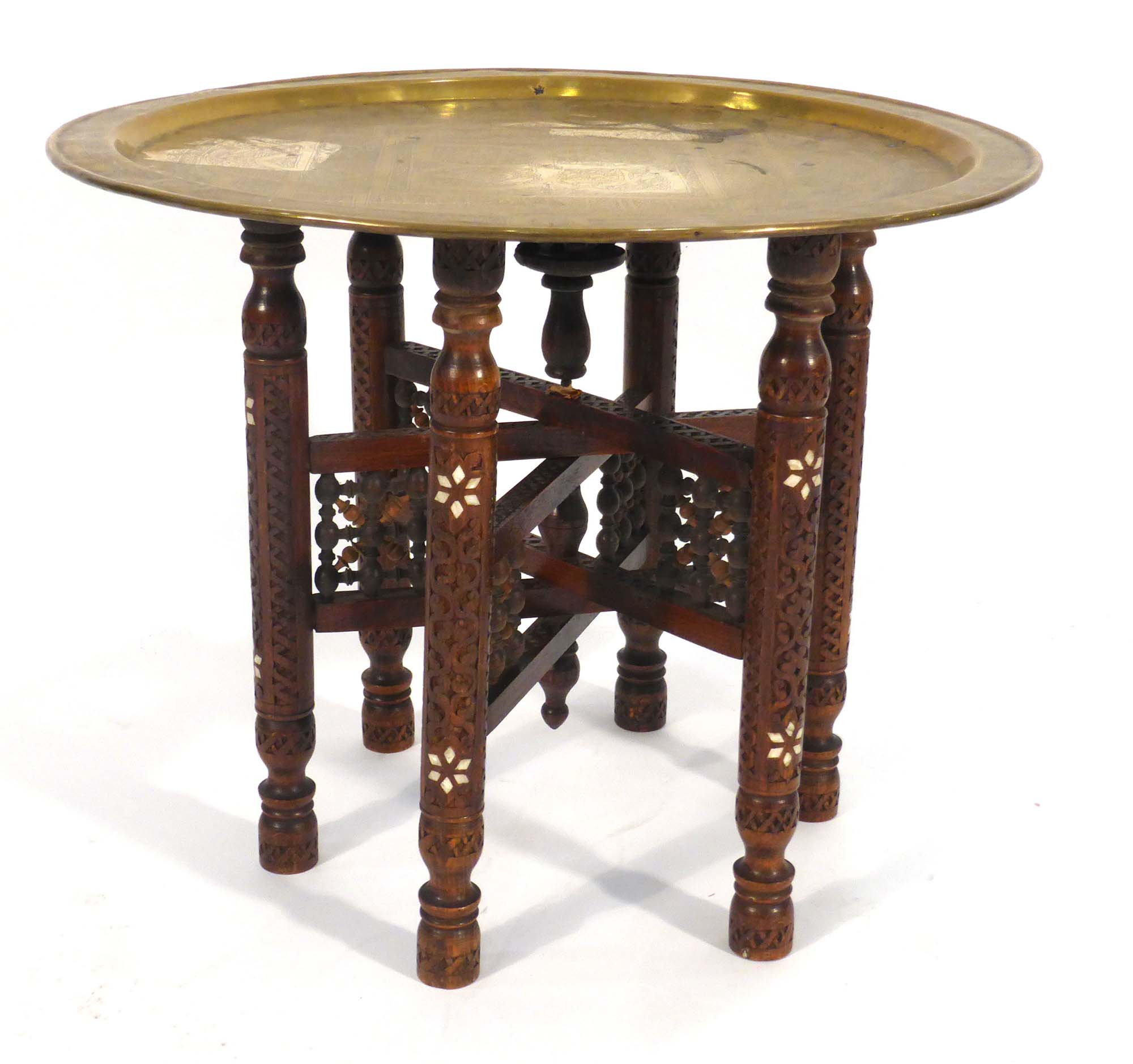 An Eastern tray table, the brass tray resting on a hardwood and mother-of-pearl inlaid folding base,