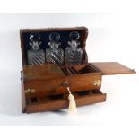 A Victorian oak three bottle tantalus with silver plated mounts, two lift doors and a single drawer,