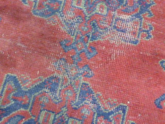 An early 20th century red ground rug with repeated motifs within red and blue bands, - Image 6 of 8