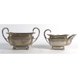 A George III silver two handled sugar bowl of boat shaped form having gadrooned and shell