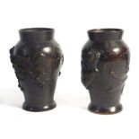 A pair of Japanese brown patinated bronze vases of ovoid form relief decorated with a dragon and an