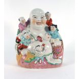 A Chinese figure modelled as the Buddha and five clambering children, h. 26.
