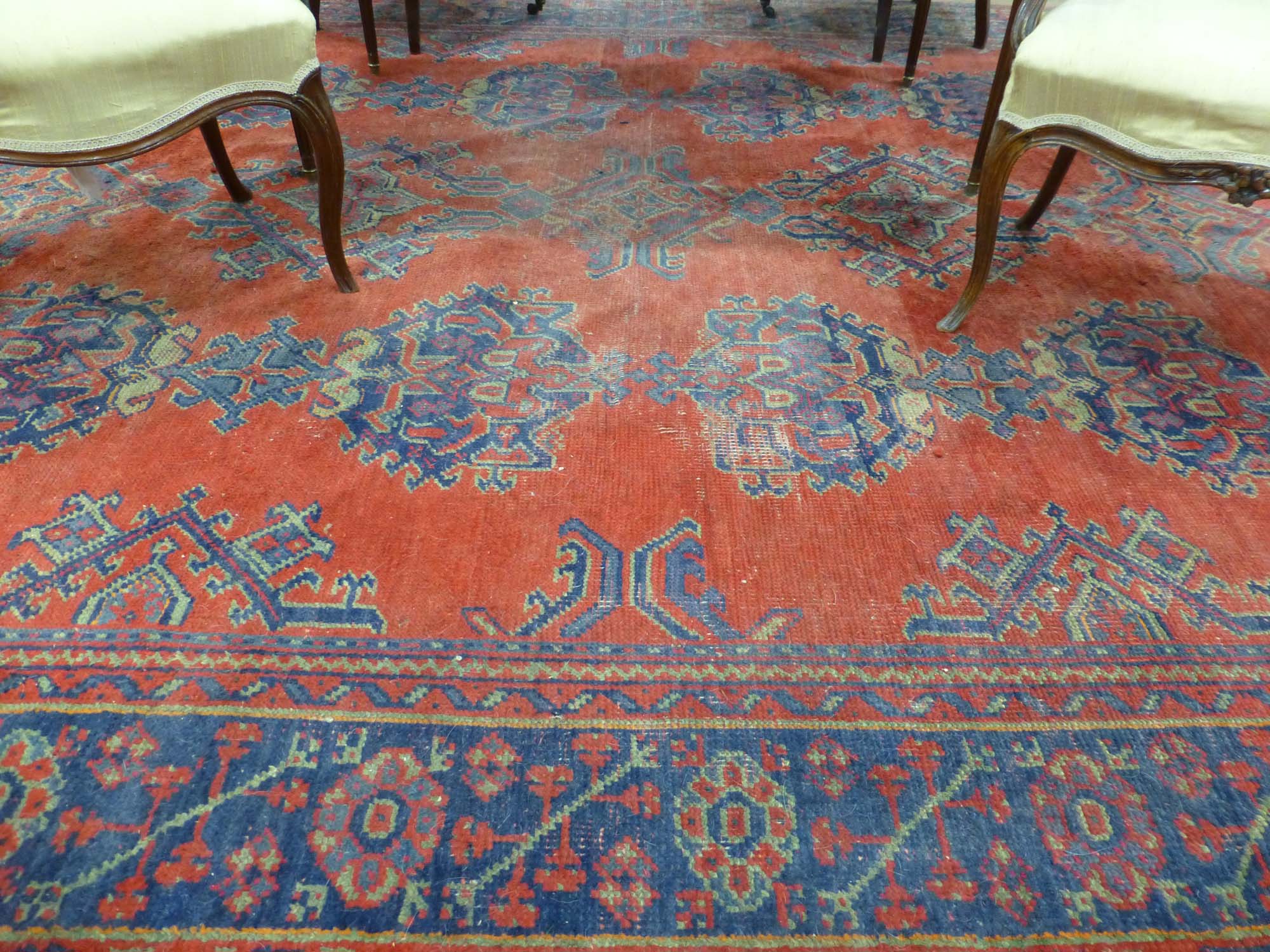 An early 20th century red ground rug with repeated motifs within red and blue bands, - Image 2 of 8