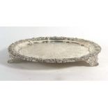 A George IV silver salver of circular form with cast foliate border on three conforming feet,