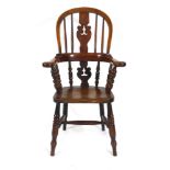 A childrens walnut and beech Windsor chair with shaped splat and turned legs joined by a cross