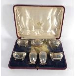 An early 20th century cased condiments set containing seven silver cruets of canted vase shaped