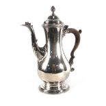 A George III silver coffee pot of pear shaped form, the cover with flame finial,
