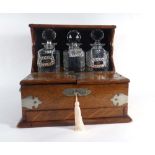 A Victorian oak three-bottle tantalus with silver plated mounts,