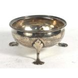 A George IV hammered silver dish with beaded border raised on three outswept feet, maker GC,