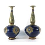 A pair of Royal Doulton vases, the bulbous bodies below slender necks,