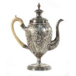 A George III silver coffee pot of vase shaped form repousse decorated in the rococo manner on a