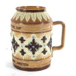 A Doulton Lambeth salt glazed 'moto' jug 'Bitter must be the cup that a smile will not sweeten', h.