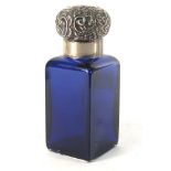 A Victorian Bristol blue bottle with repousse decorated silver lid, makers mark indistinct,