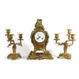 A late 19th century French mantle clock and garnitures, the enamelled face with Roman numerals,
