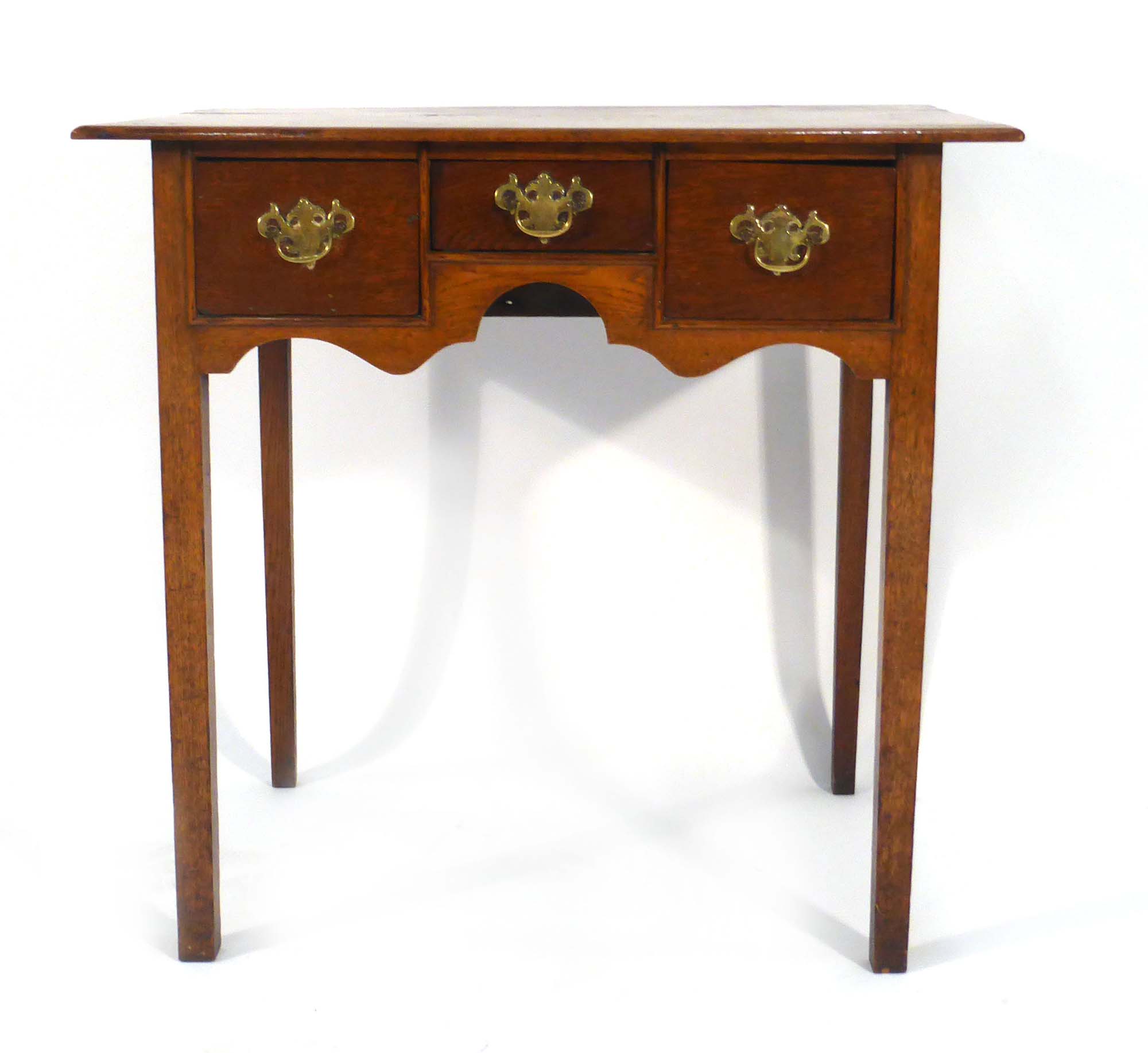 An 18th century oak lowboy with an arrangement of three drawers over a shaped apron on square