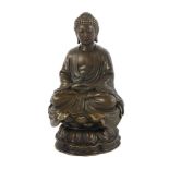 A brown patinated bronze figure modelled as the Buddha in meditation on a lotus base, h.