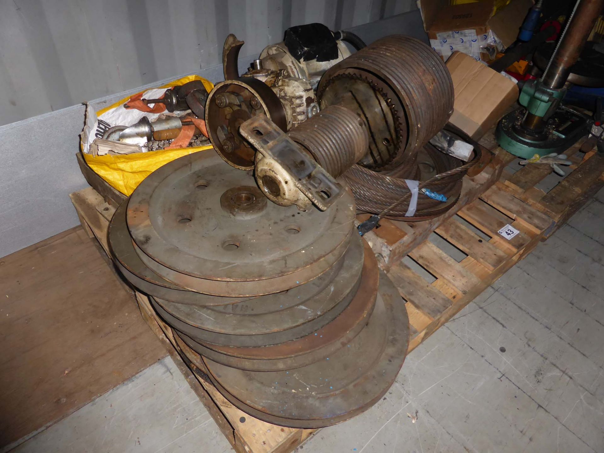 Pallet of used heavy duty electric motor, flywheels, winch wheels and wire rope