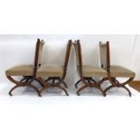 A set of four Victorian walnut and upholstered dining chairs on X-frame supports with castors
