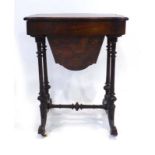 A Victorian walnut and inlaid sewing table with a fitted interior on turned supports joined by a