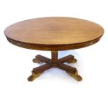 A 19th century rosewood and brass inlaid centre table, the oval surface on a square straight column,