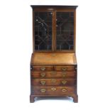 A George III mahogany harlequin bureau bookcase with glazed doors over a fall front on bracket feet,