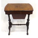 A Victorian walnut and inlaid sewing table with a fitted interior on two supports joined by a cross