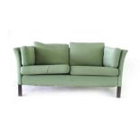 A green cloth two-seater sofa on mahogany square legs