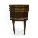 A late George III mahogany and brass bound cellarette/wine cooler of octagonal form with a