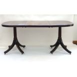 A Regency mahogany twin pedestal dining table, with one fitted leaf, max. l.