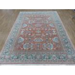 An Egyptian Zeigler-style woolen rug decorated with floral sprays on a salmon pink 'abrash' ground,