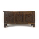 An 18th century and later oak coffer, the front with three carved panels, on square straight stiles,